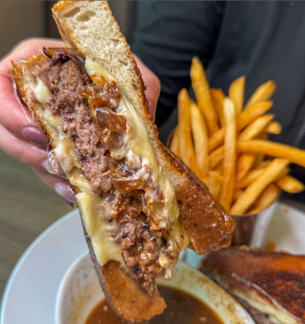 A French onion burger on grilled Texas toast with melted provolone and au jus