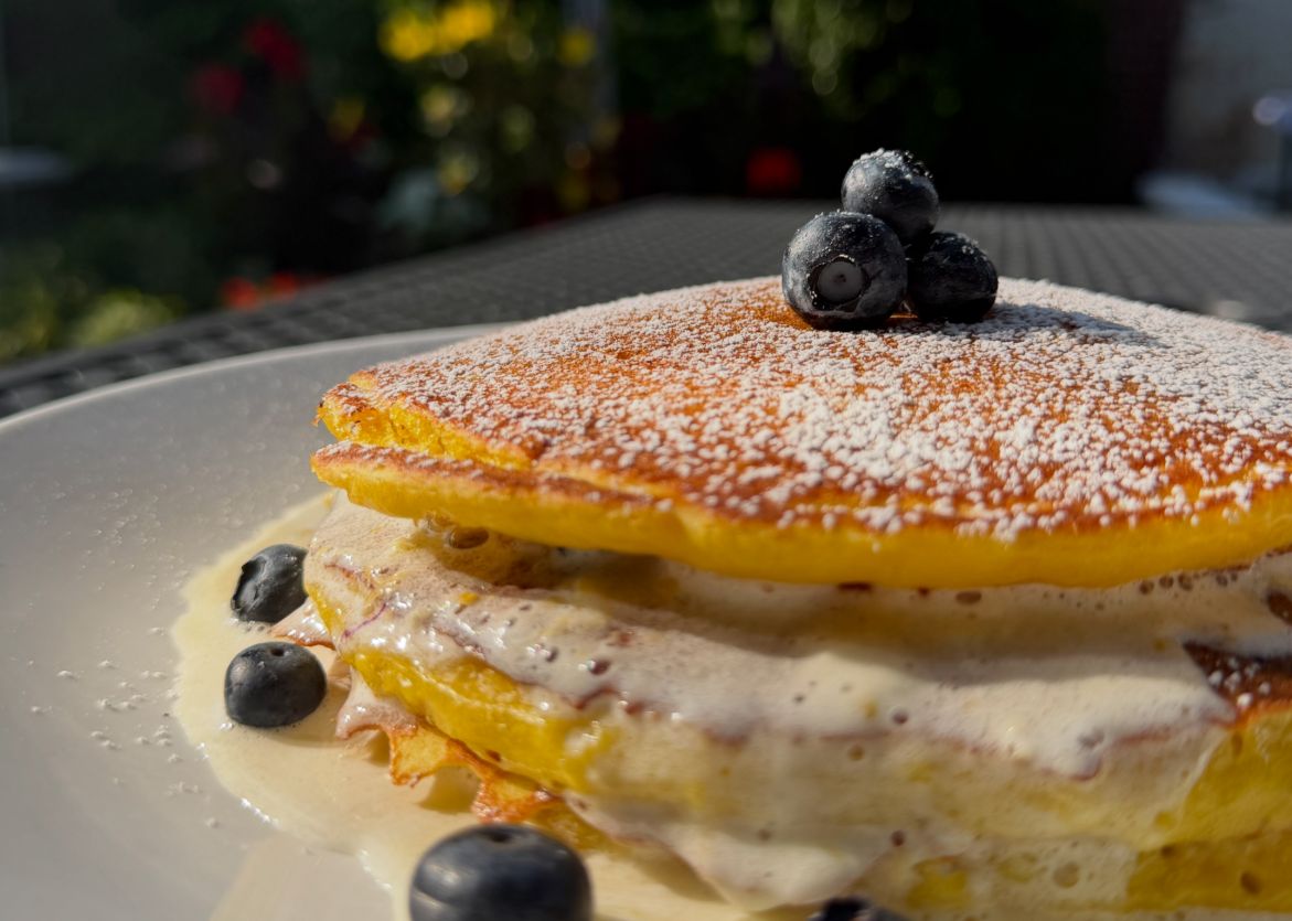 A lemon blueberry pancake stack dusted with powdered sugar