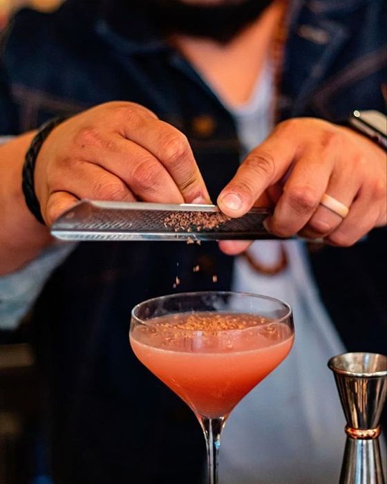Grating a garnish over a finished drink