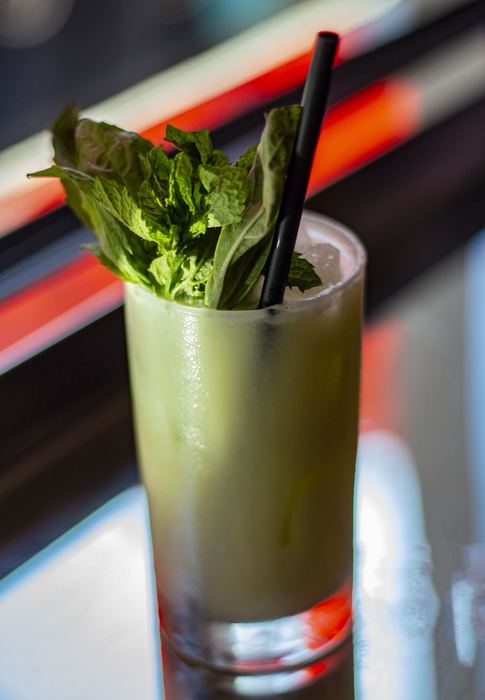 A herb-topped green cocktail in the booth