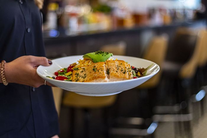 Blackened salmon, plated and carried to the table
