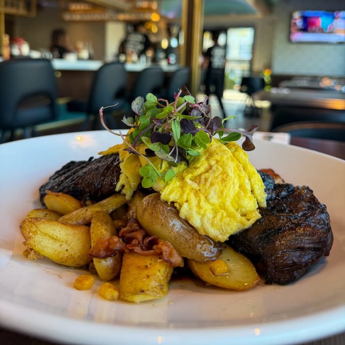 Steak N Eggs: grilled skirt steak and eggs over a bacon, potato and roasted corn hash