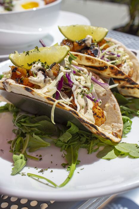 Tacos plated with pickled onion and greens